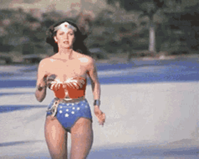 Живая ретро gif картинка с Линдой Картер из фильма чудо женщина 1975 года, бегущей по пляжу.