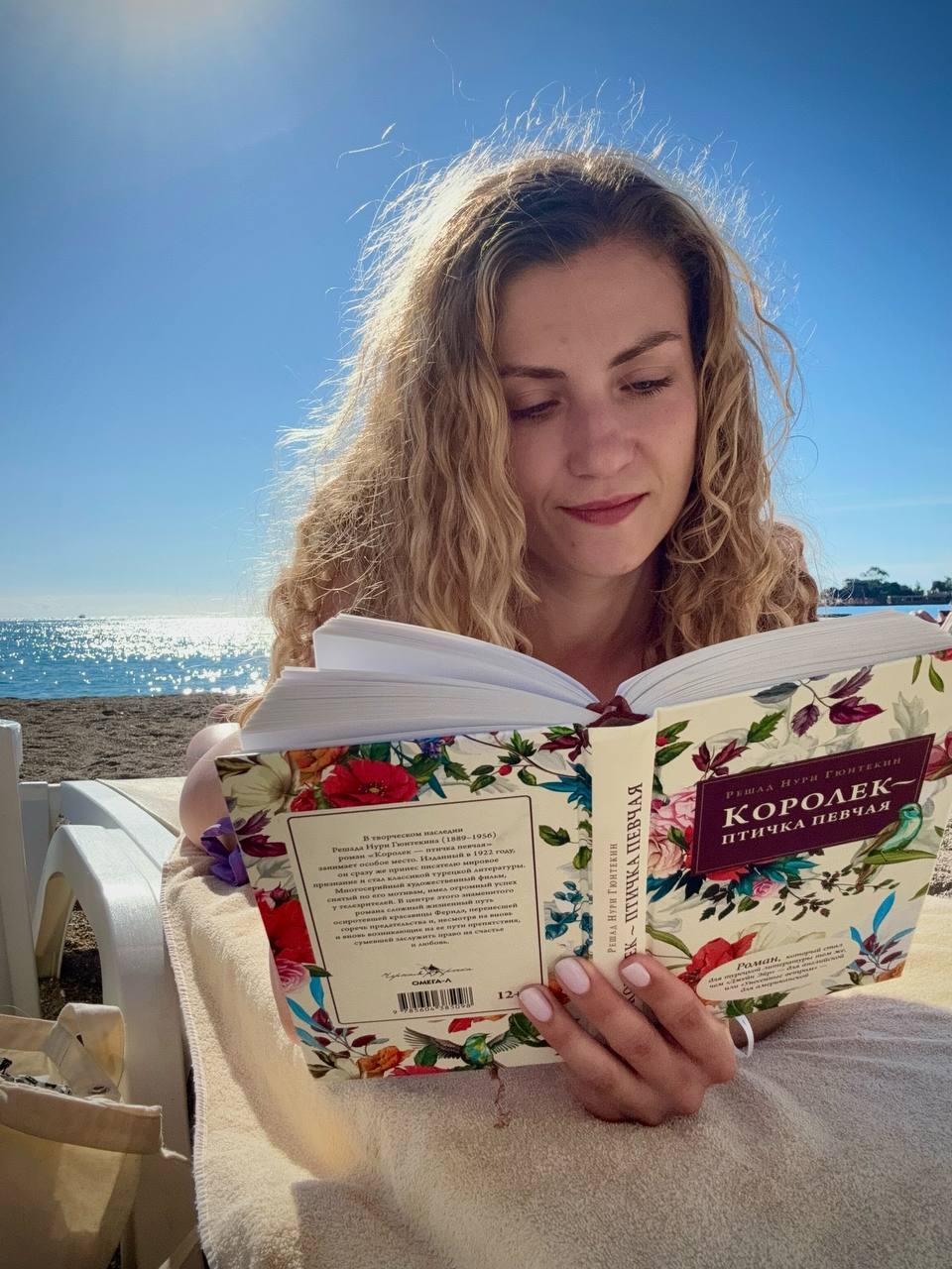 Откровенный снимок Бунтиной на пляже за чтением книги.