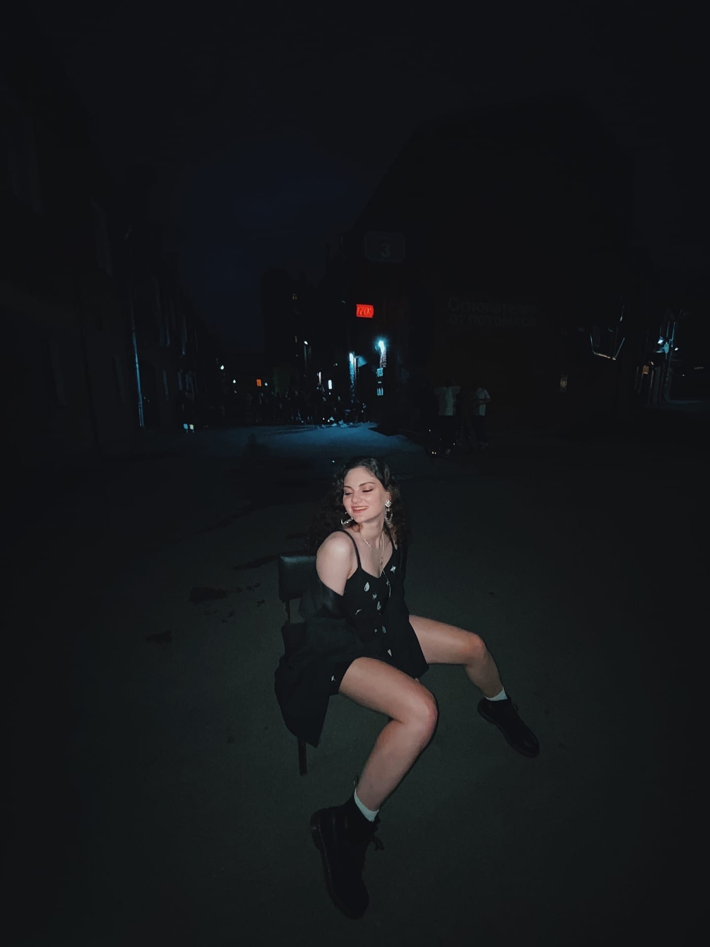 Фото ночью на стуле по среди города.
