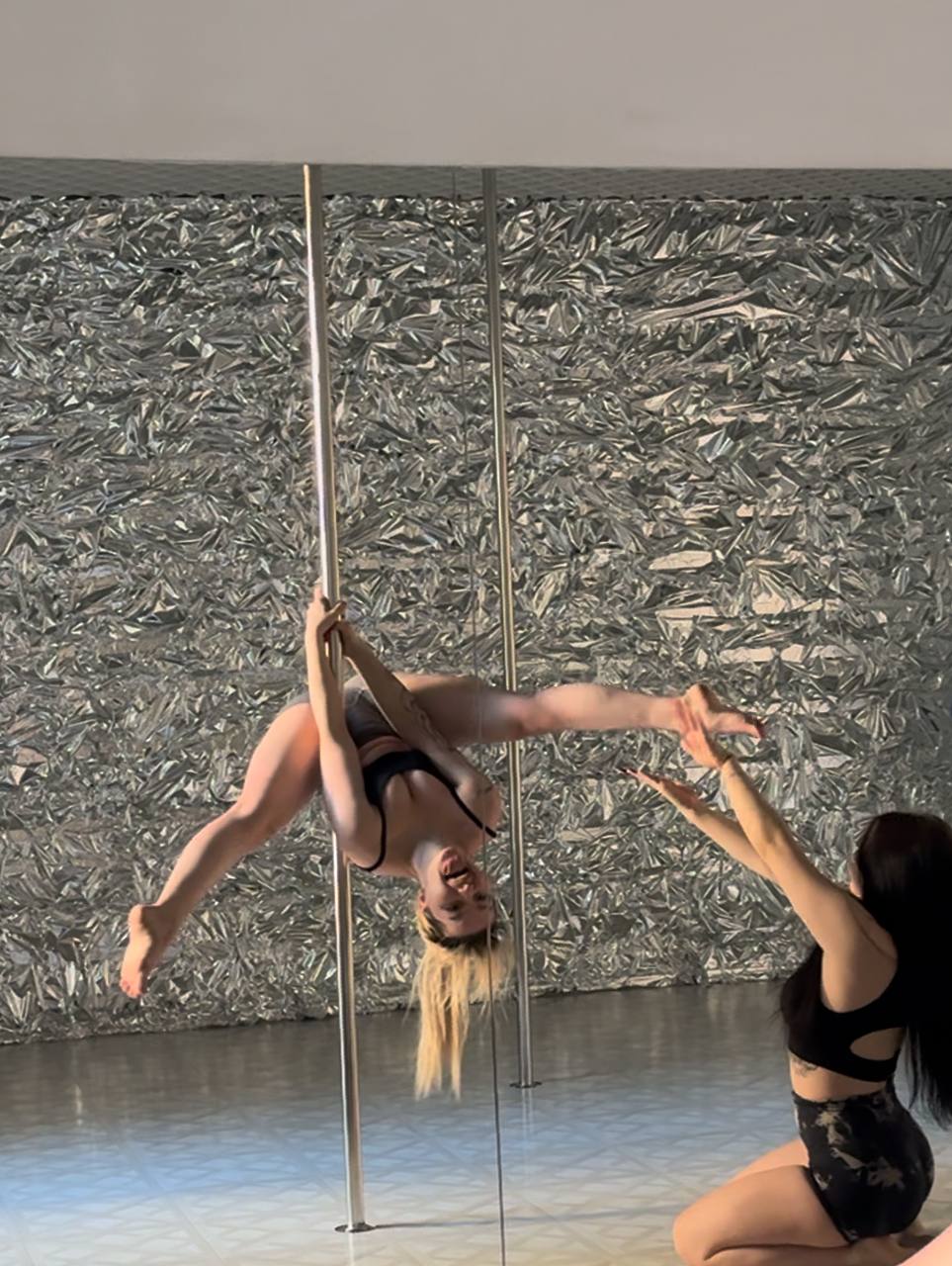 А на этой смешной фотке Musclekitty в чёрном лифчике и труселях висит с разведёнными ногами на шесте.