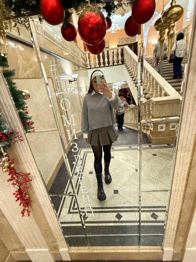 Ещё одно селфи от Насти в новогоднем стиле в юбке и чулках.